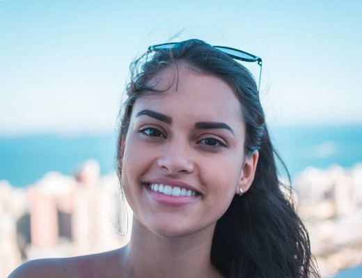 Smiling Woman Wearing Sunglasses at the Beach